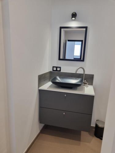 a bathroom with a sink and a mirror at Maisonnette entièrement rénovée in Givet