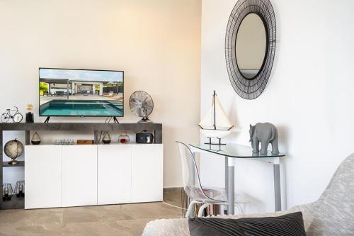 a living room with a tv and a mirror at KAY SE MI in Case-Pilote