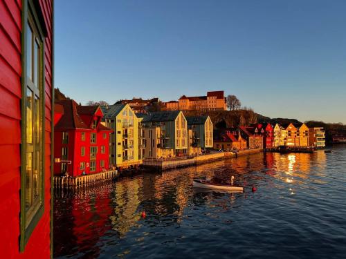 een rivier met kleurrijke gebouwen en een boot in het water bij Central Seafront Apartments with Parking and Self Check-In! in Bergen