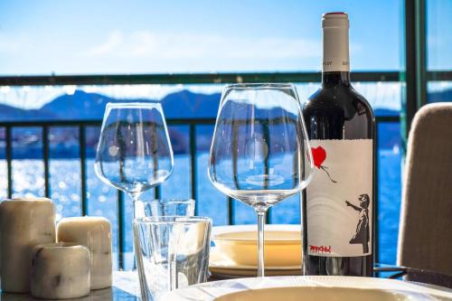 een tafel met twee wijnglazen en een fles wijn bij Central Seafront Apartments with Parking and Self Check-In! in Bergen