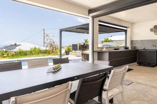 an open kitchen and dining room with a view of the ocean at KAY SE MI in Case-Pilote