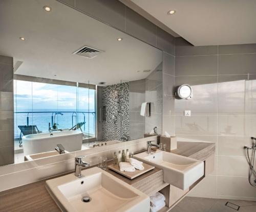 a bathroom with two sinks and a large mirror at DoubleTree Resort by Hilton Hotel Penang in Batu Ferringhi