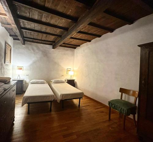 ein Zimmer mit 2 Betten und einem Stuhl darin in der Unterkunft Casa Renata in Arcidosso