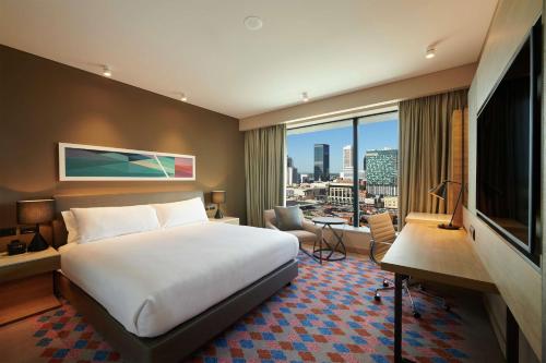 a hotel room with a bed and a large window at Doubletree By Hilton Perth Northbridge in Perth