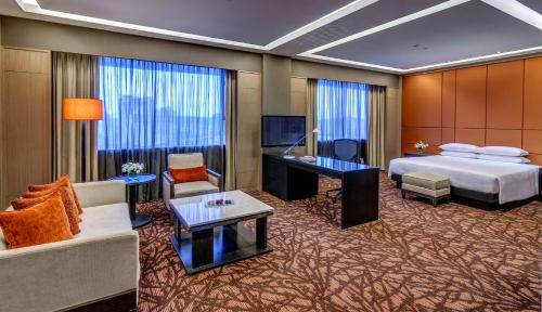 a hotel room with a bed and a living room at Hilton Petaling Jaya in Petaling Jaya