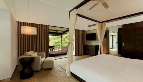 a bedroom with a bed and a living room at Hilton Shillim Estate Retreat and Spa in Lonavala