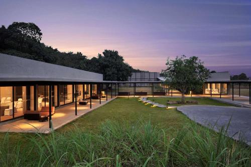 an exterior view of a building with a lawn at Dharana at Shillim All Inclusive Luxury Wellness Retreat in Lonavala
