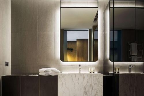 シドニーにあるウェスト ホテル シドニー キュリオ コレクション バイ ヒルトンのバスルーム(洗面台、鏡付)