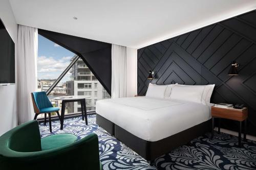 1 dormitorio con cama, escritorio y silla en West Hotel Sydney, Curio Collection by Hilton en Sídney