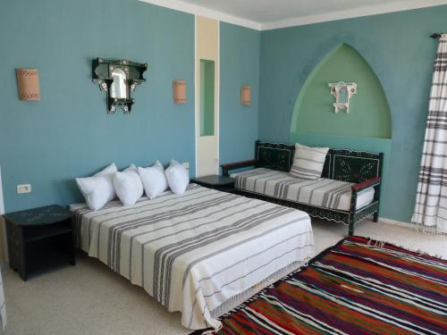 two beds in a room with blue walls at Dar Amphora Menzel in Midoun