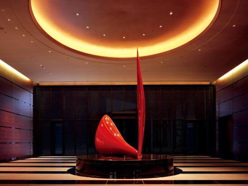 a red chair in a room with a circular ceiling at Conrad Tokyo in Tokyo