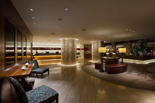 a lobby of a hotel with chairs and tables at Hilton Tokyo Hotel in Tokyo
