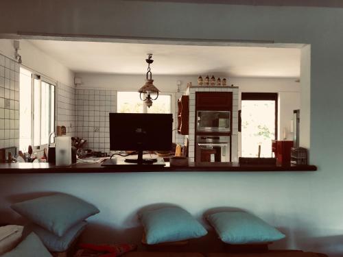a kitchen with a counter with pillows and a tv at Ti Vanillier in Petit-Bourg