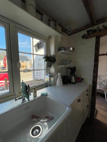 a kitchen with a sink and a large window at Pittelille - supercozy small luxury in Henningsvær in Henningsvær