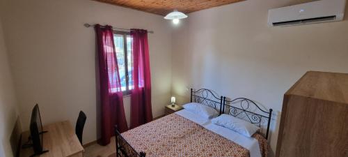 1 dormitorio con 1 cama y una ventana con cortinas rojas en Villa Rosetta - Casa Vacanze, en Palmi