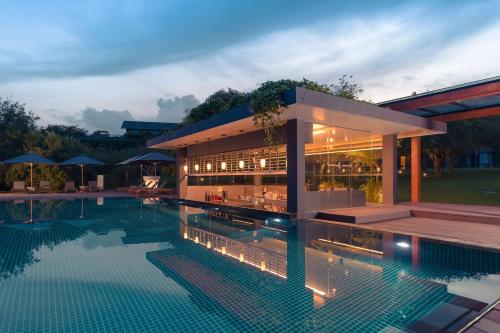 a building with a swimming pool in front of it at DoubleTree by Hilton Weerawila Rajawarna Resort in Weerawila