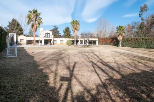 einen großen Hof mit Palmen und einem Haus in der Unterkunft La Moni in Las Compuertas