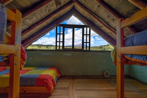 a attic room with two bunk beds and a window at MAUCA PEDREGAL in Machachi