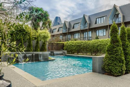 a swimming pool in front of a building at Chateau On The Park - Christchurch, A Doubletree By Hilton in Christchurch