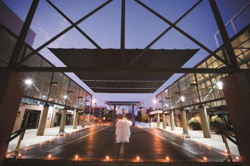 a bride walking down the aisle of a building at night at DoubleTree by Hilton Esplanade Darwin in Darwin