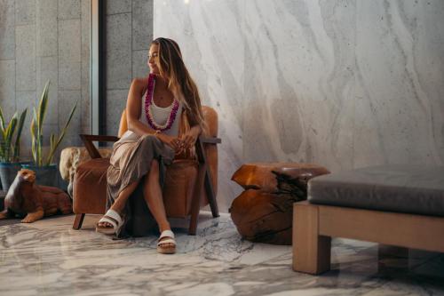 a woman sitting in a chair in a room at Hotel La Croix in Honolulu