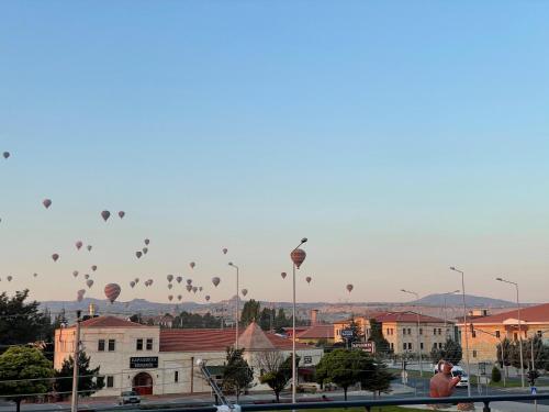 a bunch of hot air balloons flying over a city at Apart Angel Suit 3 in Nevşehir