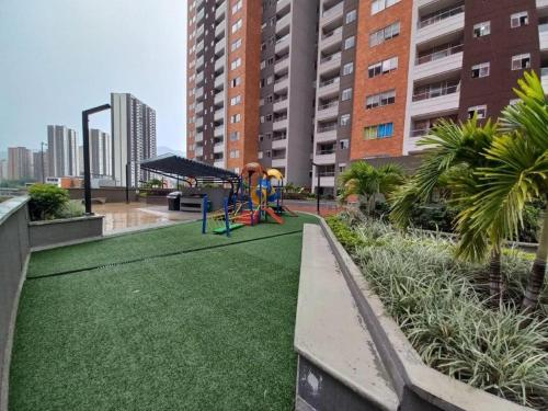a park with a playground with green grass and buildings at Sabaneta Apto tres habitaciones a 10 minutos CC Mayorca in Sabaneta