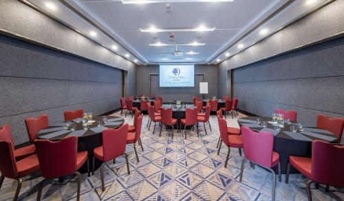 a conference room with tables and chairs and a screen at DoubleTree by Hilton Putrajaya Lakeside in Putrajaya