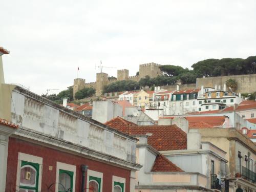 a group of buildings with a castle in the background at New Aljubarrota Guest House in Lisbon