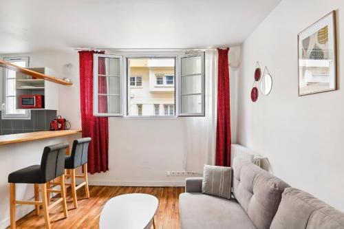 un salon avec un canapé et une table dans l'établissement Studio Jaurès - Equipped studio near Paris with private Bathroom, à Montrouge
