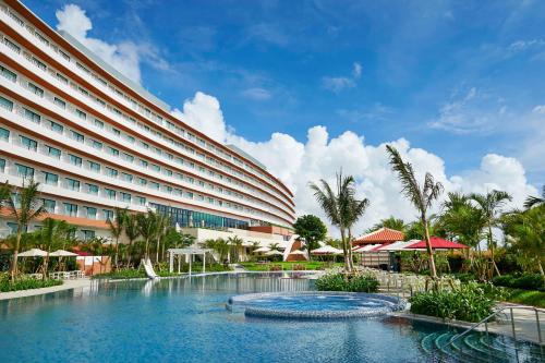a hotel with a swimming pool in front of a building at Hilton Okinawa Chatan Resort in Chatan