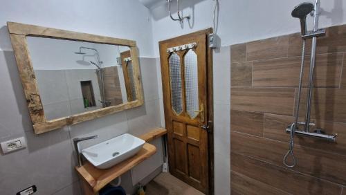 een badkamer met een wastafel en een spiegel bij Bujtinat Skenderi Gjinar in Gjinar