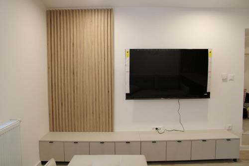 a flat screen tv hanging on a wall at Urban Den in Sarajevo