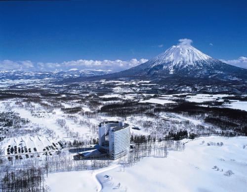 een uitzicht op een met sneeuw bedekte berg met een stad bij Hilton Niseko Village in Niseko