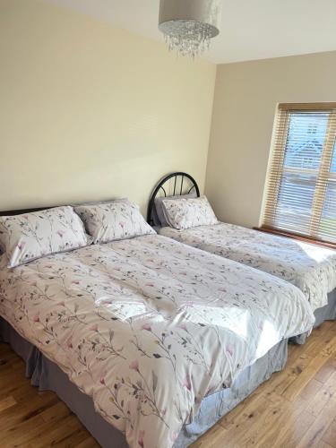 a bedroom with two beds and a chandelier at Dunalinn, Culdaff in Culdaff