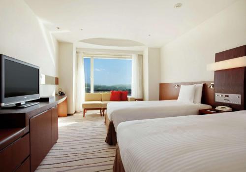 a hotel room with two beds and a flat screen tv at Hilton Niseko Village in Niseko