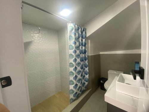 a bathroom with a shower curtain and a sink at Suits Mirador de Luz in Cuenca