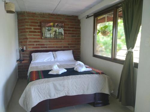 a bedroom with a bed with towels on it at Romeo y Julieta, cabaña privada en Minca in Minca