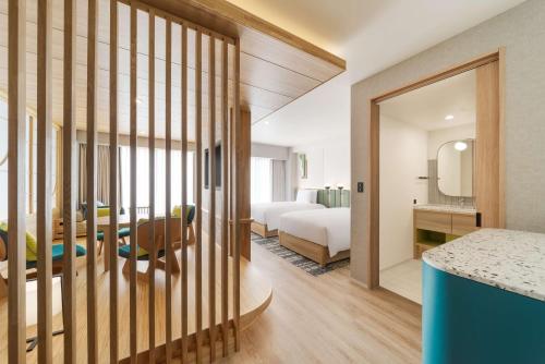 a hotel room with a bed and a dining room at Hilton Garden Inn Kyoto Shijo Karasuma in Kyoto