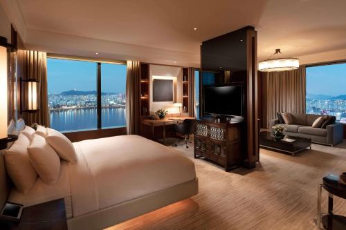 首爾的住宿－首爾康拉德酒店，一间带大床的卧室和一间客厅