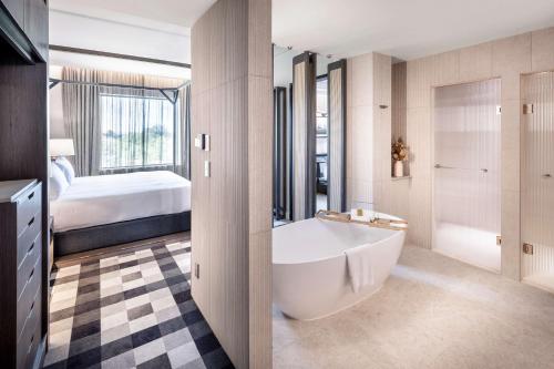 Doubletree By Hilton Karaka في أوكلاند: حمام مع حوض وغرفة نوم مع سرير