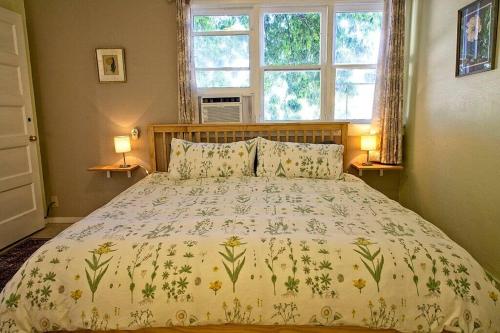 1 cama en un dormitorio con 2 lámparas y una ventana en Historic Clarkdale apartment #104, en Clarkdale