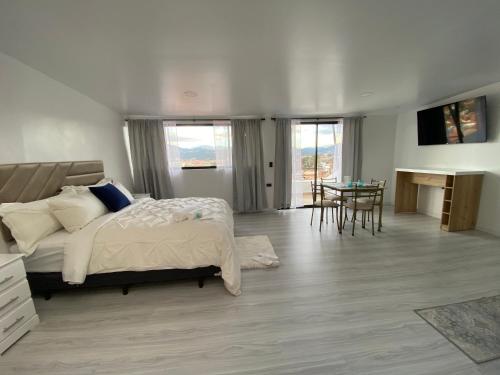 a bedroom with a bed and a table and a desk at Suits Mirador de Luz in Cuenca