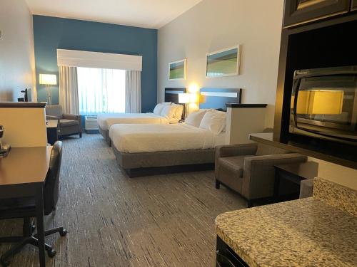 a hotel room with two beds and a couch at Holiday Inn Express and Suites Montgomery by IHG in Montgomery