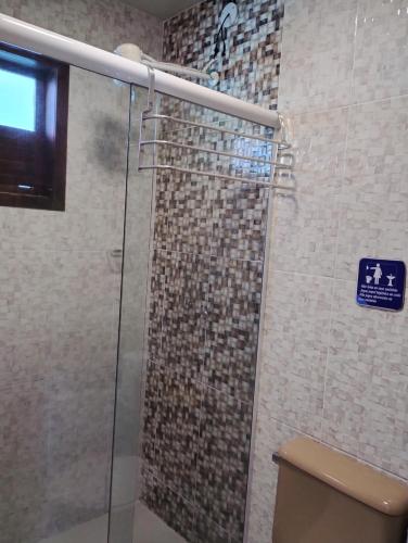 a bathroom with a glass shower with a toilet at Pousada Paraíso do Atlântico in Arraial do Cabo