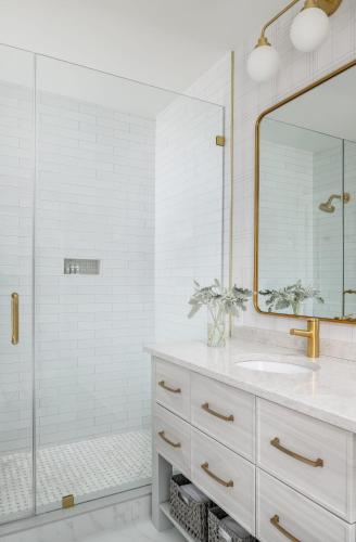 a white bathroom with a sink and a shower at The Oaks Waterfront Hotel in Saint Michaels