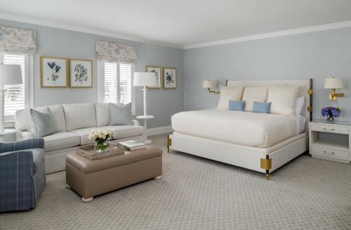 a bedroom with a bed and a living room with a couch at The Oaks Waterfront Hotel in Saint Michaels