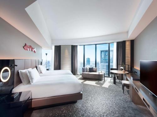 um quarto de hotel com uma cama e uma televisão em Conrad Osaka em Osaka