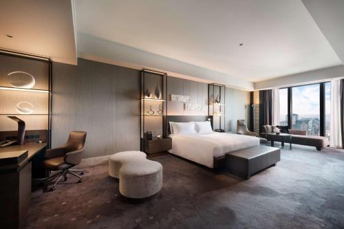 a hotel room with a bed and a desk at Conrad Osaka in Osaka