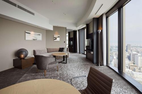 a living room with a couch and a table at Conrad Osaka in Osaka